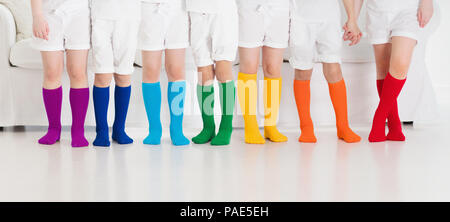 Kinder tragen bunte Regenbogen Socken. Kinder Schuhe Kollektion. Vielzahl von gestrickte Kniestrümpfe und Strumpfhosen. Kind Kleidung und Bekleidung. Kid fash Stockfoto