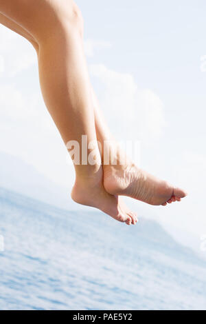 Weibliche Füße am Meer. Rest auf einer Yacht. Eine junge Frau, die auf dem Sun sunbathes Stockfoto