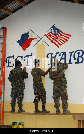 Santos City, Philippinen (Feb. 18, 2007) - Philippinische Soldaten helfen Freundschaft Flags, die mit einem Builder 3. Klasse Rouel Agustin (rechts), vom Schiffsbau Bataillon drei Malen, auf der Seite des Chongco Grundschule. Ein neues Gebäude wurde im Rahmen des Projekts Freundschaft, eine humanitäre Hilfe/Community service Projekt, das die Streitkräfte der Philippinen, die Crew der USS Blue Ridge LCC (19), USA 7 Flotte Personal und Marines und Seabees. Blue Ridge besucht die Philippinen über einen Zeitraum von zehn Tagen in der Freundschaft zu beteiligen - Gebäude und goodwill-Aktivitäten Stockfoto