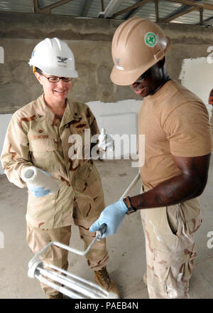 Dschibuti (Feb. 18, 2011) Petty Officer 3rd Class Jemol Gresham, zu Naval Mobile Konstruktion Bataillon (NMCB) 74 Detail am Horn von Afrika (Det zugeordnet. HOA), gibt eine kurze Lektion auf Malerei Innenwände zu US-Marine Kapitän Kathryn Donovan, Commodore 22 Schiffbau Regiment, an der Ecole 5 Grundschule Projekt in Dschibuti Feb 18. Kapitän Donovan besuchte mit Mitgliedern der NMCB 74 und führenden Persönlichkeiten der Combined Joint Task Force Horn von Afrika (CJTF-HOA), um sicherzustellen, dass die seabees effektiv in die Konstruktion Engineering Support Unterstützung der CJTF-HOA in Übereinstimmung mit der U verwendet werden. Stockfoto