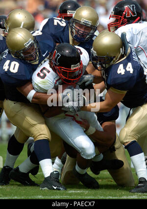 Md. (Sept. 11, 2004) Р ein Trio der US Naval Academy Midshipman Verteidiger angriff Nordöstlichen Schlittenhunde' Quintin Mitchell während der Marine Gewinn über der Nordöstlichen 28-24. Die Midshipmen für 300 Yards gehetzt auf 58 trägt und Hinzufügen von 36 Yards durch die Luft bei Navy-Marine Corps Memorial Stadium. Marine (2-0), die gezogenen 17-14 an der Hälfte, hat seine ersten zwei Spiele der Saison zum ersten Mal seit 1996, als es der Aloha Schüssel gewonnen, gewonnen. U.S. Navy Stockfoto