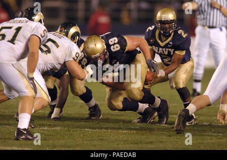 San Diego - Dez. 22, 2005 -- U.S. Naval Academy center James Rossi (C) Hände weg vom Ball zu quarterback Lamar Owens. Navy beat Colorado State 51-30 in der konstituierenden Poinsettia-schüssel am Donnerstag, 31.12.22, an San DiegoХs Qualcomm Stadion. Das Spiel war auf ESPN ausgestrahlt. U.S. Navy Stockfoto