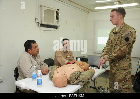 Us-Armee Sgt. Aaron Marsh, Recht, ein Medic mit Firma F, 2nd Battalion, 238Th Aviation Regiment, Task Force Heavy Cav., beauftragt die irakischen Aviation Mediziner, in der Irakischen Flug Mediziner Kurs eingeschrieben, die auf der Beurteilung einer Abdominal- Wunde in der Brust- und Bauchhöhle trauma Training im Camp Taji, Irak, 31. März 2016. Us-Armee die Ärzte, die die irakischen Soldaten in einer Vielzahl von korrekten medizinischen Techniken und lebensrettenden Fähigkeiten geschult. Die Schulung ist Teil des gesamten Combined Joint Task Force - inhärenten Building Partner Kapazität mission Lösen die militärische Kapazität der irakischen Sicherheit Fo zu erhöhen. Stockfoto