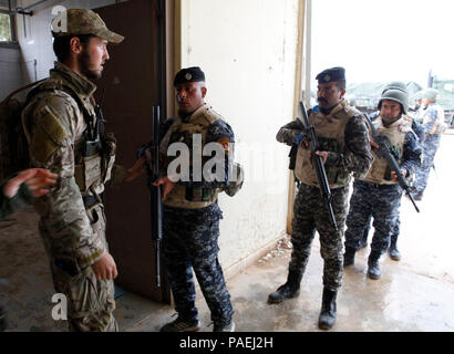 Eine Königliche Dänische Armee Soldat, Links, mit Task Force Al Asad, beauftragt die irakischen Bundespolizei Mitglieder auf, wie man einen gewaltsamen Eintrag während der militärischen Operationen in urbanem Gelände Ausbildung bei Al Asad Air Base, Irak, 28. März 2016 führen. Die kleine Einheit militärischen Taktik Schulung ist Teil des Gebäudes der Kapazitäten der Mission, die die militärischen Fähigkeiten der irakischen Sicherheitskräfte erhöht die Islamischen Staat im Irak und der Levante zu kämpfen. Durch die ISF durch beraten und unterstützen, und BPC-Missionen, die Combined Joint Task Force - Betrieb die Lösung der multinationale Koalition Stockfoto