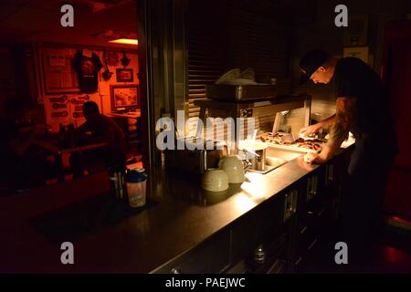 Petty Officer 1st Class Zachary Hassilev, ein Food Service Spezialisten an Bord USCGC Kukui (WLB 203), bereitet midrats während der Fahrt die Durchführung einer Strafverfolgung und Fischerei Patrouille in den Pazifischen Ozean, 19. März 2016. Midrats auf crewmitglieder stehen die midwatch serviert von 11:30 Uhr bis 3:30 Uhr (US- Coast Guard Foto von Petty Officer 2. Klasse Melissa E. McKenzie/Freigegeben) Stockfoto