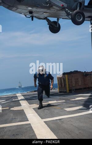 160331-N-ZH 960-130 WESTERN PACIFIC (31. März 2016) - der bootsmann Mate Seemann Zachary Lang löscht den Flight Deck nach Anbau eines Cargo hook zu einem MH-60S Sea Hawk bei einer vertikalen Nachschub die Ladegeräte der Hubschrauber Meer Combat Squadron (HSC) 14 zugeordnet auf See an Bord der geführte Anti-raketen-Zerstörer USS Stockdale (DDG106). Die Bereitstellung einer bereit, Kraft für die Sicherheit und Stabilität in der Indo-Asia - Pazifik, Stockdale arbeitet als Teil des John C Stennis Strike Group und Große grüne Flotte in regelmäßigen 7 Flotte Bereitstellung. (U.S. Marine Foto von Massenkommunikation Spezialist Stockfoto