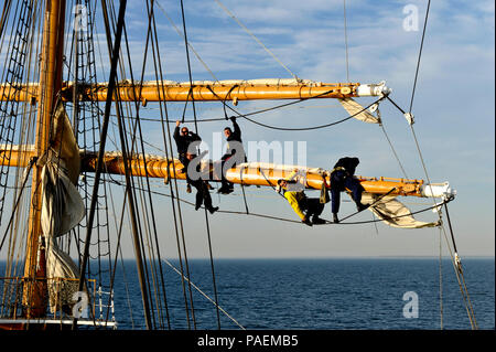 Coast Guard Cutter Eagle Crewmitglieder reparieren Segel beschädigt während in den Atlantischen Ozean, Mittwoch, 23. März 2016 im Gange. Besatzungsmitglieder sind geschult auf See erlittene Schäden zu reparieren. U.S. Coast Guard Foto von Petty Officer 2. Klasse Matthew S. Masaschi. Stockfoto