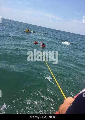 Ein Coast Guard Station Islamorada 33-Fuß-Special Purpose Handwerk - Strafverfolgung boatcrew ziehen zwei Menschen in Sicherheit Samstag, 14. Juli 2018 von einem Gekenterten Boot in der Nähe von Walen Hafen in Islamorada, Florida. Die beiden Leute hatten keine Verletzungen. U.S. Coast Guard Foto mit freundlicher Genehmigung der Station Islamorada Stockfoto