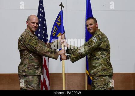 Oberst Scott Gibson, 407 Air Expeditionary Gruppenkommandant und Presiding Officer, präsentiert die 407 Expeditionary Sicherheitskräfte Squadron guidon, Maj. Roger Howard bei einem Befehl Zeremonie an einem geheimen Ort im Südwesten Asien, 15. Juli 2018. Maj. Aaron Gulczynski Befehl des Geschwaders zu Howard während der Zeremonie verzichtet. (U.S. Air Force Foto von älteren Flieger Kenneth Boyton) Stockfoto