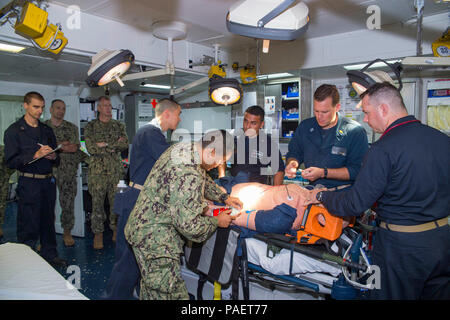 180717-N-RD 713-1090 Pearl Harbor, Hawaii (17. Juli 2018) der hinteren Adm. Paul Pearigen, dritter von links, Commander, Marine Medizin West, und Command Master Chief Loren Rucker, zweiter von links, command Master Chief der Marine Medizin West, beobachten eine medizinische Antwort Demonstration von Seglern der Flotte Op-Team (FST) 5 als Teil einer Tour des Amphibious Assault ship USS BONHOMME RICHARD (LHD6) während der Rand der Pazifischen (Rimpac) 2018 Übung. 25 Nationen, 46 Schiffe, 5 U-Boote, über 200 Flugzeuge und 25.000 Angestellte beteiligen sich an Rimpac vom 27. Juni bis 2. August in und um Stockfoto