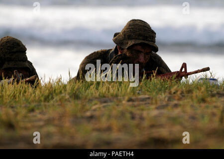 Marine Sgt. Jonathan Schannep (rechts) von San Leandro, Kalifornien, ein Assistent, Team Leader mit 4 Force Reconnaissance Firma, 2 Platoon, und Marine Sgt. Eric Anderson von Corona, Kalifornien, ein Assistent, Radio Telefon mit der platoon, rub Sand auf ihre Gesichter für Tarnung nach an Land schwimmen 23.08.2014, an der Kaneohe Bay Bereich Training Service während der letzten Mission Profil des Unternehmens (FMP). Die FMP war der letzte Teil einer zweiwöchigen jährliche Ausbildungszeit, wenn mehr als 130 4 Force Reconnaissance Company Marinen Übungen einschließlich Feuer und Abriss, kleine b Stockfoto