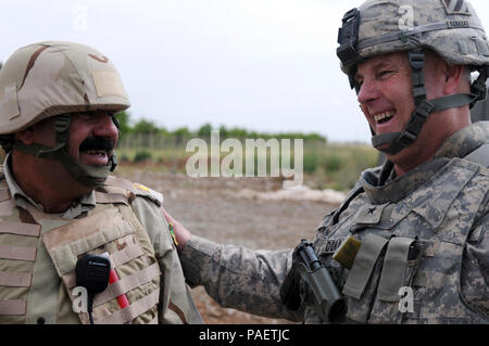 Us-Armee Brig. Gen. Patrick J. Donahue, II, stellvertretenden kommandierenden General (Manöver) 3 Infanterie Division, teilt ein Lachen mit einem irakischen Officer vor einem Ribbon Cutting in Nasaria, Irak, Mai 3. Soldaten aus Bravo Truppe, 6 Staffel, 1.Kavallerie Regiments, 1st Brigade Combat Team, 1 Armor Division, schlossen sich die Mitglieder des Rashaad Sub-distrcit Rat mit einem "Ribbon Cutting für die Schule, die fünf Dörfer und mehr als 75 Teilnehmer unterstützen wird. Stockfoto