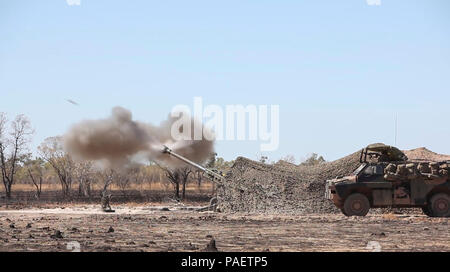 M777A2 lightweight 155 mm Haubitze mit 101 Batterie, 8./12 Regiment, Royal Australian Artillerie, der Australischen Armee, Brände ein Projektil zur Unterstützung eines US Marine Corps Air Assault Kurs Juni 29 im Feld Bradshaw, Northern Territory, Australien. Die AAC wurde eine bilaterale kombinierte Waffen Schulungsveranstaltung, die kombiniert leichte Infanterie, Indirektes Feuer Waffensysteme und die Vermögensgegenstände zu erfassen und durch ein mock Feind Ziel kämpfen. Die Marine die Drehkraft - Darwin Bereitstellung ermöglicht die Marines zu effektiv trainieren, Übung, und arbeiten mit ihren australischen Partnern verbessern Stockfoto