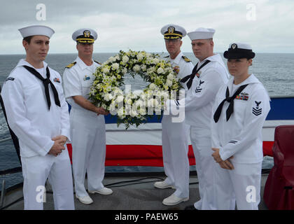 Gewässer südlich von Japan (2. April 2015) Segler zum u-boot Tender USS Frank Kabel zugewiesen (40) pose mit einem Kranz für eine Zeremonie zum Gedenken an den 70. Jahrestag der Schlacht von Iwo Jima. Die Zeremonie, die in der Schlacht kämpfte und enthalten ein persönliches Zeugnis von Seglern, die Familie, Kampf in der Schlacht, Festlegung eines Kranzes, ein 21-gun Salute und das Spielen von Wasserhähnen geehrt. Frank Kabel, sich auf der Insel Guam eingesetzt, führt die Wartung und den Support von U-Booten und Überwasserschiffen in den USA 7 Flotte Verantwortungsbereich eingesetzt und ist derzeit auf einem sche Stockfoto