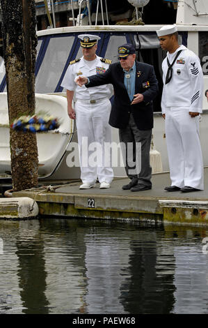 Oak Harbor, Washington (4. Juni 2012) Kapitän Jay Johnston, Links, kommandierender Offizier der Naval Air Station Whidbey Island, Cmdr. (Ret.) Harry Ferrier, eine Schlacht um Midway Veteran und Master-at-Arms 1. Klasse Adam Dickson, dem Basis Sicherheit zugewiesen, werfen einen Kranz bei einem Festakt zum 70. Jahrestag der Schlacht von Midway zu gedenken. Die Schlacht von Midway war der Wendepunkt in der pazifischen Krieg während des Zweiten Weltkrieges. Stockfoto