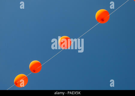 Orange Luftballons und blauen Himmel im Hintergrund. Stockfoto