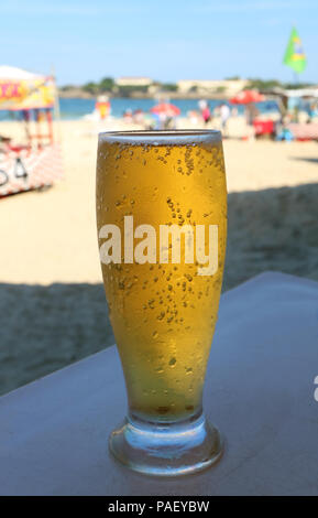 Vorderansicht eines Glas kaltes Bier am sonnigen Strand von Copacabana in Rio de Janeiro, Brasilien Stockfoto