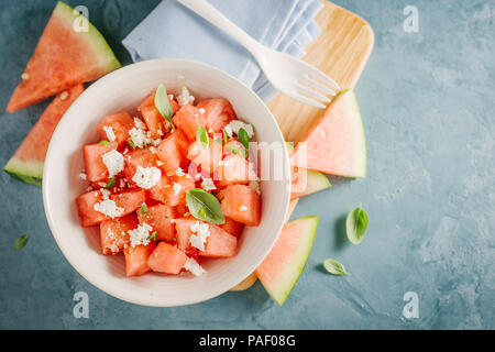 Frische leckere Sommer Salat mit Wassermelone und Feta Käse würfeln, Basilikum in der Schüssel. Serviert und bereit zu essen. Reinigen Detox Weight Loss Konzept Stockfoto