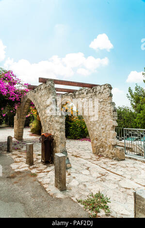 Pavillon für wicker Rosen und Blumen im Dorf der Künstler auch aus groben Steinen, aber bedeckt mit Holzbalken, so dass Pflanzen auf Halten Können Stockfoto