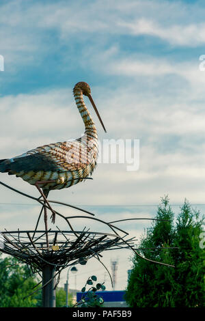 Dekorative Storch im Nest gegen den blauen Himmel Stockfoto