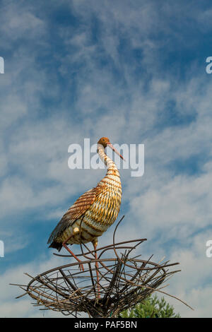 Dekorative Storch im Nest gegen den blauen Himmel Stockfoto