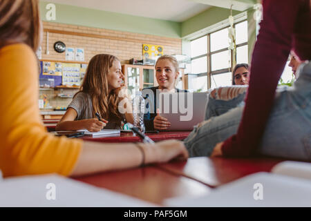 Gruppe von jungen Menschen sprechen im Unterricht nach der Vorlesung. Studenten plaudern während der Pause zwischen den Vorlesungen. Stockfoto