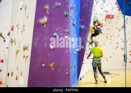 Foto der jungen Mädchen Ausübung auf Kletterwand mit Trainer Stockfoto