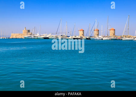 Windmühlen und St Nicholas Turm und Leuchtturm im Hafen Mandraki in Rhodos, Dodekanes, Griechenland Stockfoto