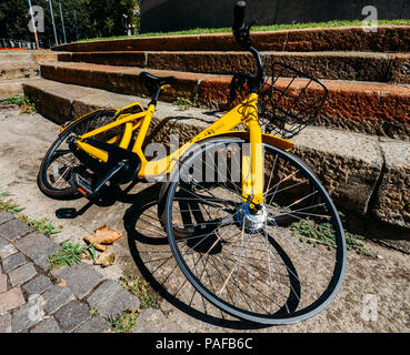 In der Nähe des beschädigten Reifens auf gelben Ofo Bike-sharing Mailand, ein Fahrrad auf der Straße. In China gegründet, Ofo ist das weltweit erste und größte Station - kostenlose Bike Sharing Plattform Stockfoto