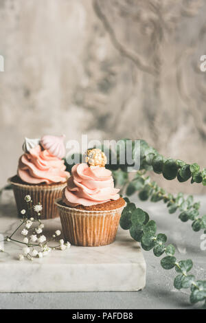 Cupcakes mit buttercream auf Marmor. Luxus Hochzeit oder Geburtstag Cupcakes. Getonten Bild Stockfoto