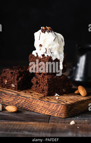 Chocolate Brownies mit Vanilleeis auf schwarzem Hintergrund. Detailansicht, selektiver Fokus Stockfoto