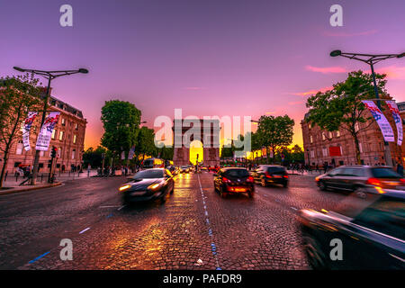 Paris, Frankreich, 2. Juli 2017: Avenue des Champs Elysees und Triumphbogen in der Dämmerung mit Verkehr Straße. Triumphbogen in einem farbenfrohen Sonnenuntergang Himmel. Stockfoto