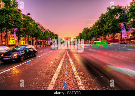 Paris, Frankreich, 2. Juli 2017: Geschwindigkeit Wirkung der Autos auf der Champs Elysees und dem Triumphbogen in der Ferne in der Dämmerung. Triumphbogen in einem farbenfrohen Sonnenuntergang Himmel. Stockfoto