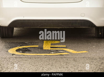 Auto deaktiviert Stellplatz mit Behinderten Logo auf dem Boden sichtbar geparkt Stockfoto