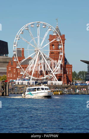 Wassertaxi überqueren Cardiff Bay mit einem großen Rad fahren vor der Pierhead Gebäude im Hintergrund Stockfoto