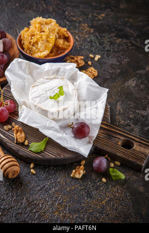 Camembert Käse mit Trauben, Honig in den Waben mit Zedern- und Walnüsse und Mandeln Stockfoto