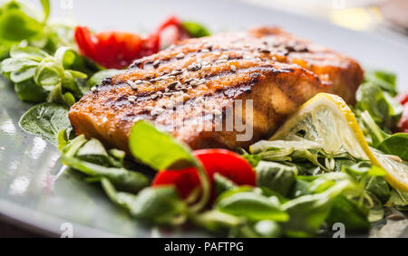Gegrilltes Lachsfilet mit Salat Tomaten und Sesam. Stockfoto