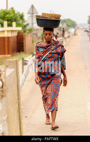 - PORTO NOVO, BENIN - Mar 9, 2012: Unbekannter beninischen Frau mit viel Material über den Kopf. Kinder von Benin Leiden der Armut aufgrund der schwierigen Stockfoto