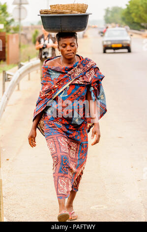 - PORTO NOVO, BENIN - Mar 9, 2012: Unbekannter beninischen Frau mit viel Material über den Kopf. Kinder von Benin Leiden der Armut aufgrund der schwierigen Stockfoto