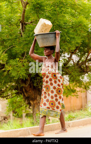 - PORTO NOVO, BENIN - Mar 9, 2012: Unbekannter beninischen Frau mit viel Material über den Kopf. Kinder von Benin Leiden der Armut aufgrund der schwierigen Stockfoto