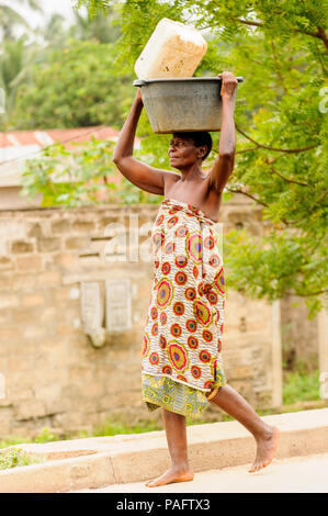 - PORTO NOVO, BENIN - Mar 9, 2012: Unbekannter beninischen Frau mit viel Material über den Kopf. Kinder von Benin Leiden der Armut aufgrund der schwierigen Stockfoto