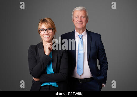 Eine attraktive Geschäftsfrau und mittleren Alters eine exectuive Professionelle man stehend an isolierten Hintergrund. Stockfoto