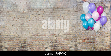 Eine Menge Luftballons an der Vorderseite der Ziegel Wand. Stockfoto