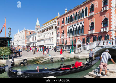 Gondoliere in einem bunten Gondel wartet, um zu Exit Rio del Vin, Castello, Venedig, Venetien, Italien nach Auslagerung der Touristen in der Nähe das Hotel Danieli Riva d Stockfoto