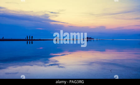 Wunderschöne natürliche Landschaft silhouette Touristen Reflexion an Nathon Strand Sonnenuntergang Sicht in der Nähe von Nathon Pier und farbenfrohen Himmel während ein Sonnenuntergang über dem Stockfoto