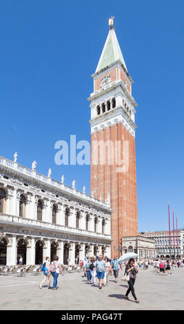 Touristen vor der St Marks Campanile und dem Marciana Nationalbibliothek, Piazetta San Marco, San Marco, Venedig, Venetien, Italien. Frau mit Sonnenschirm
