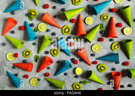 Waffel Hörner, Kalk, Kiwi, Beeren, Minze und Trauben auf einem grauen Hintergrund. Sommer Hintergrund, Konzept der gesunden Ernährung, Sommer wallpaper. Stockfoto