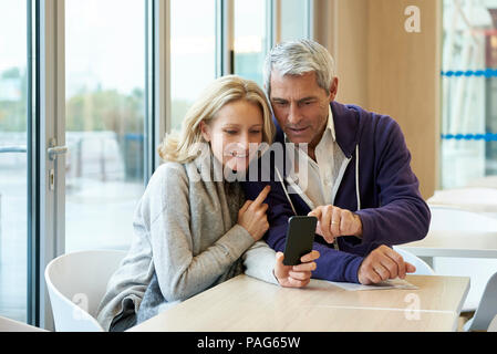 Paar mit smart phone in cafŽ Stockfoto