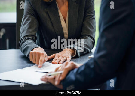 Geschäftsleute, die Schreibarbeit zu diskutieren Stockfoto