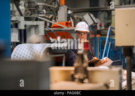 Arbeiter mit Klemmbrett in der Factory Stockfoto